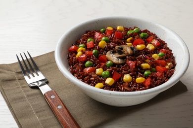 Photo of Bowl with cooked brown rice served on table