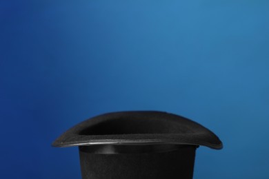 Photo of Magician's hat on blue background, space for text