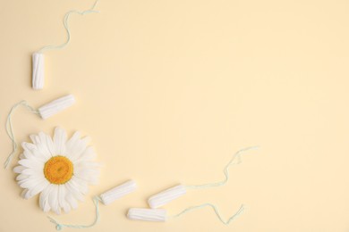 Tampons and chamomile on yellow background, flat lay. Space for text