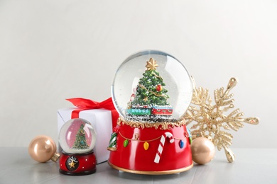 Beautiful snow globes and Christmas decor on grey table