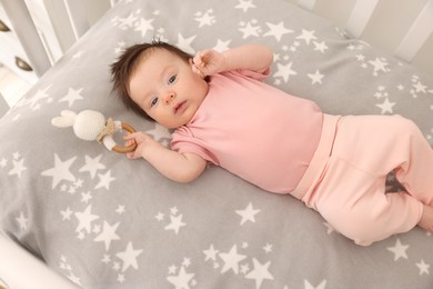 Time to sleep. Cute little baby with bunny toy lying in crib