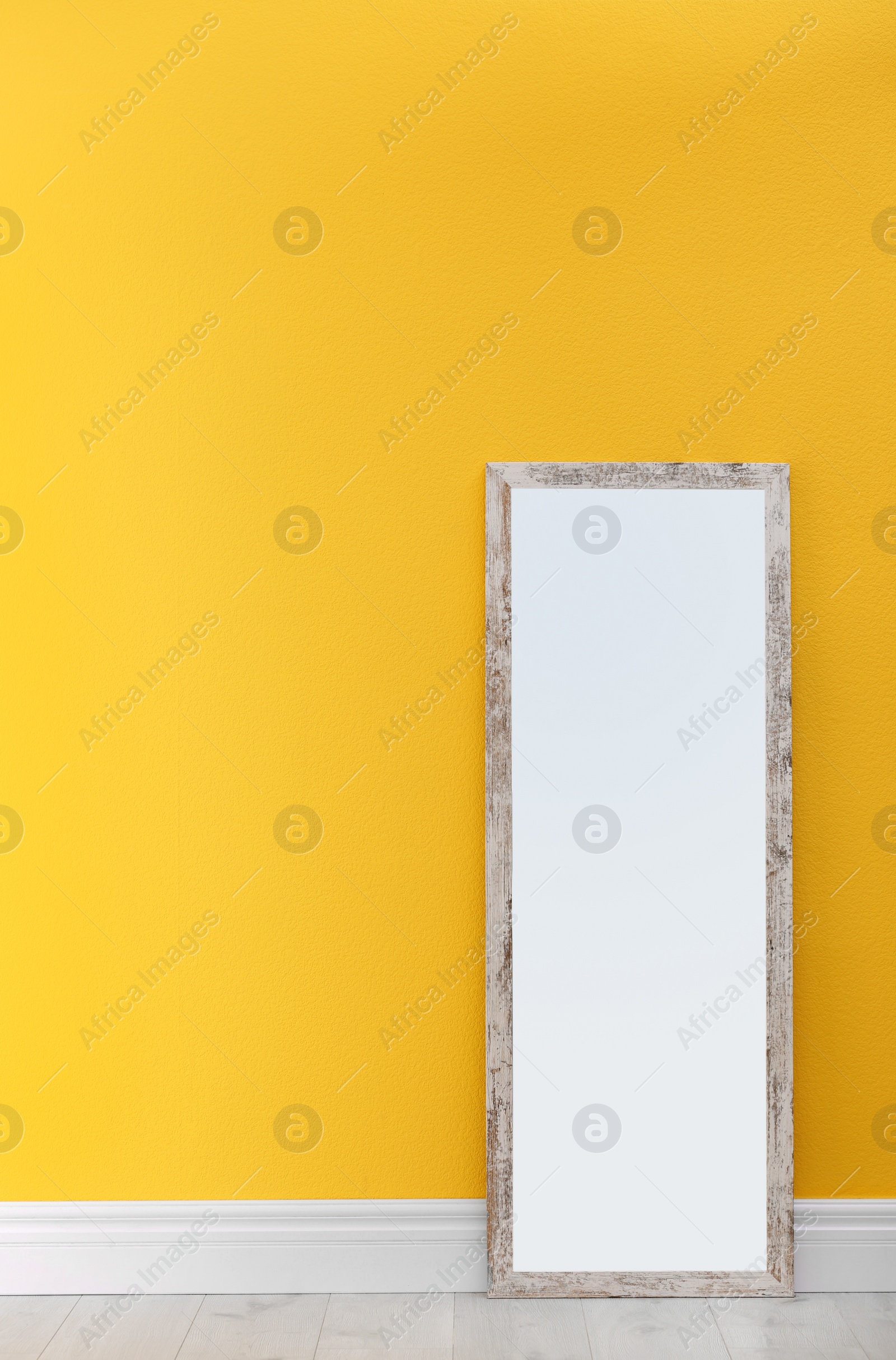 Photo of Large stylish mirror in empty room