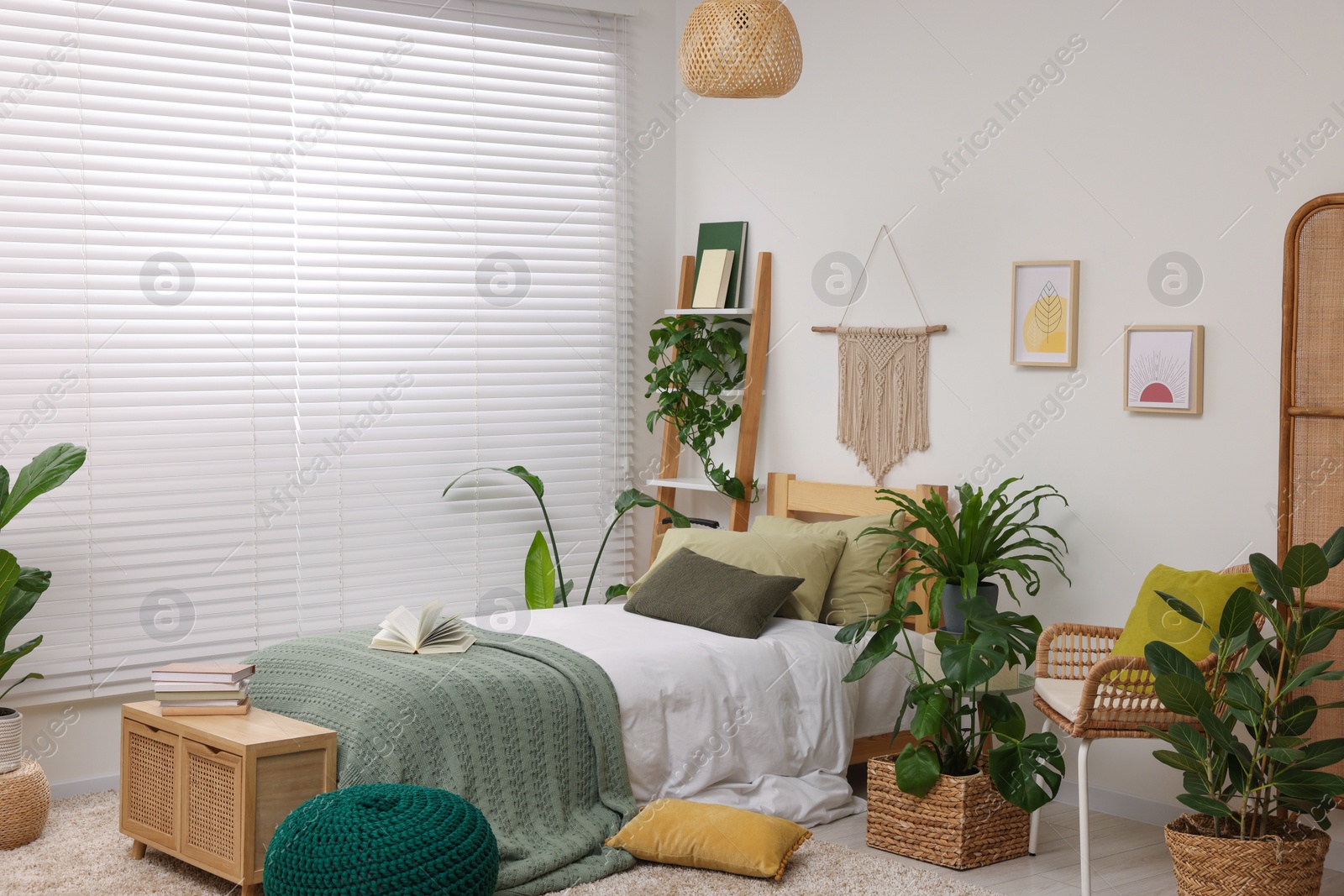 Photo of Large comfortable bed and potted houseplants in stylish bedroom. Interior design