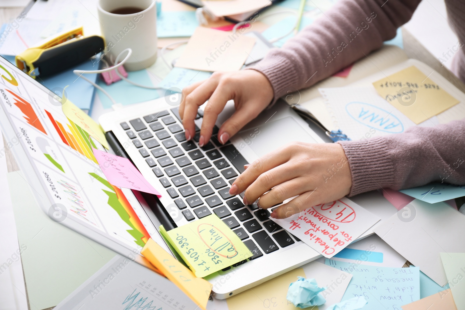 Photo of Overwhelmed woman working at messy office desk, closeup