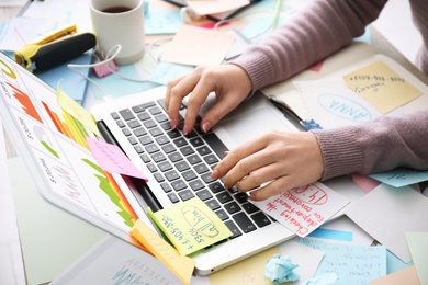 Photo of Overwhelmed woman working at messy office desk, closeup