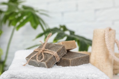 Photo of Handmade soap bars on white towel against blurred background