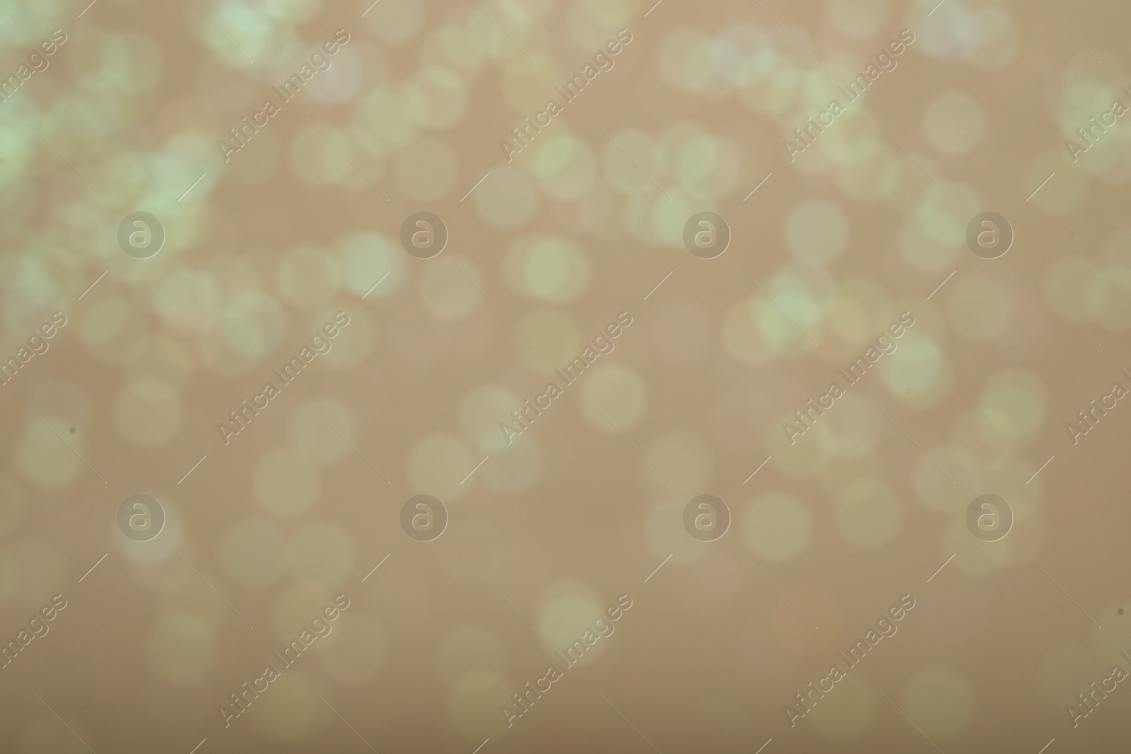 Photo of Blurred view of glitter on beige background. Bokeh effect