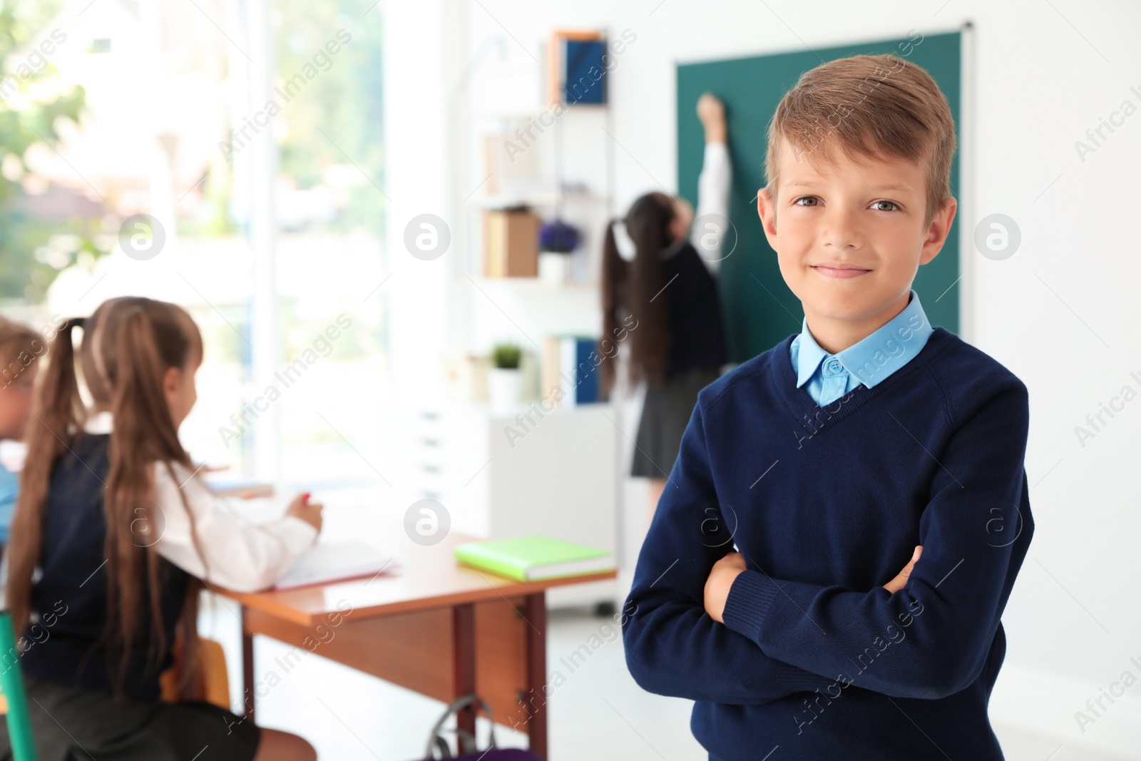 Photo of Little boy in classroom. Stylish school uniform