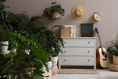 Photo of Room interior with stylish furniture and different houseplants