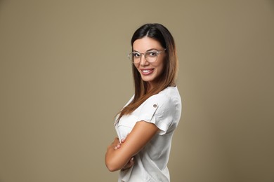 Photo of Beautiful woman in eyeglasses on beige background