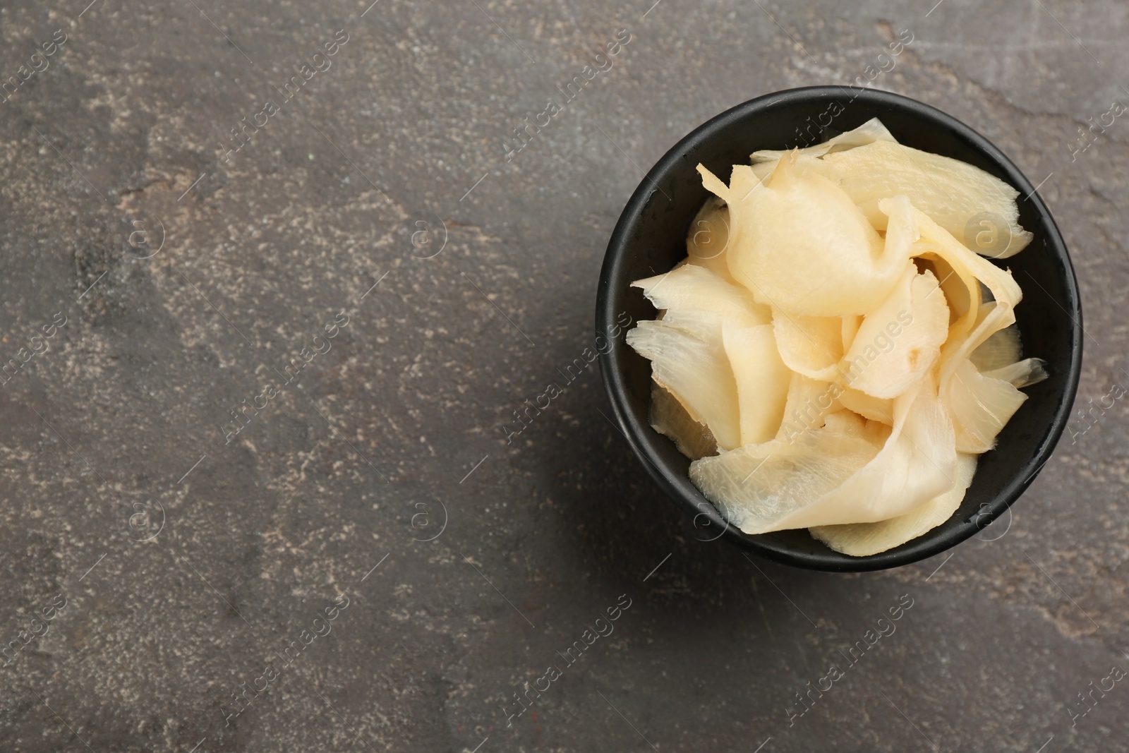 Photo of Pickled ginger in bowl on light grey table, top view. Space for text