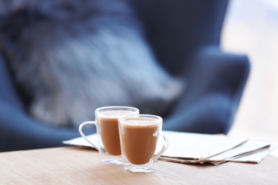 Cups of coffee and papers on table