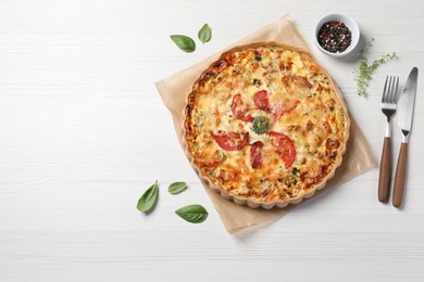 Tasty cheese quiche and cutlery on white wooden table, flat lay