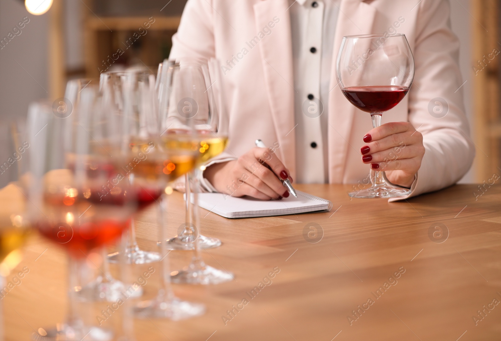 Photo of Sommelier tasting different sorts of wine at table indoors, closeup