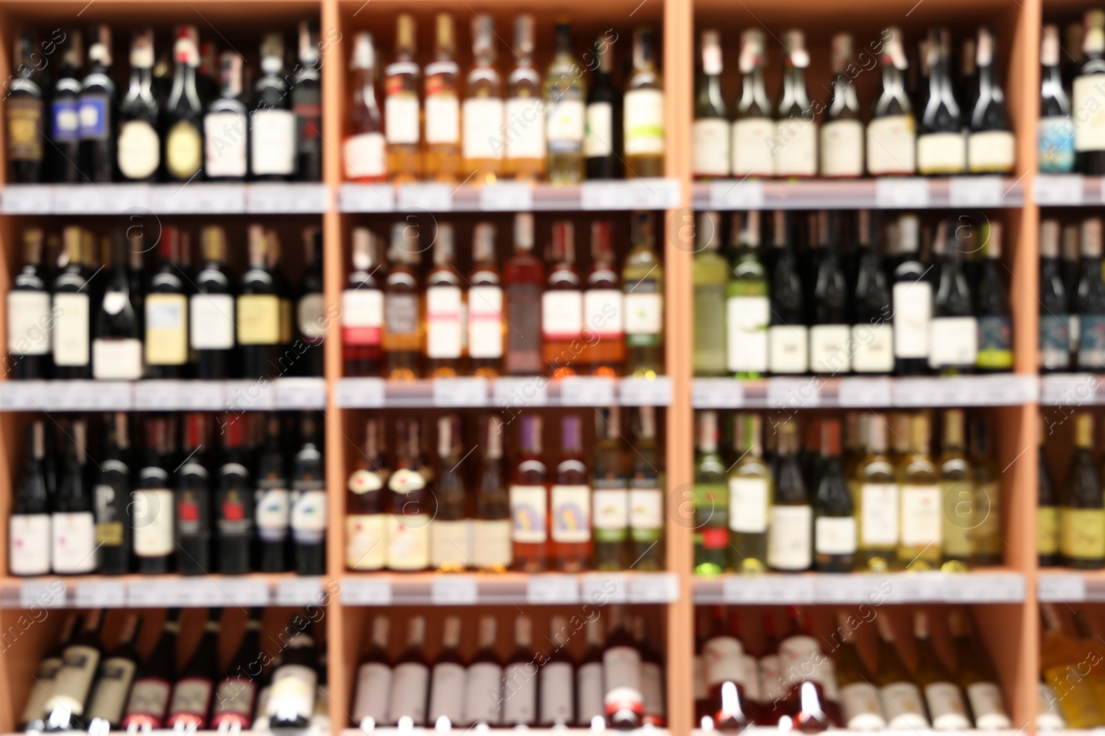 Photo of Blurred view of shelves with different wine in store. Wholesale market