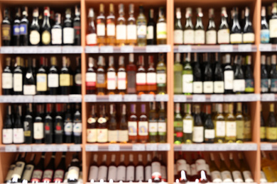 Blurred view of shelves with different wine in store. Wholesale market