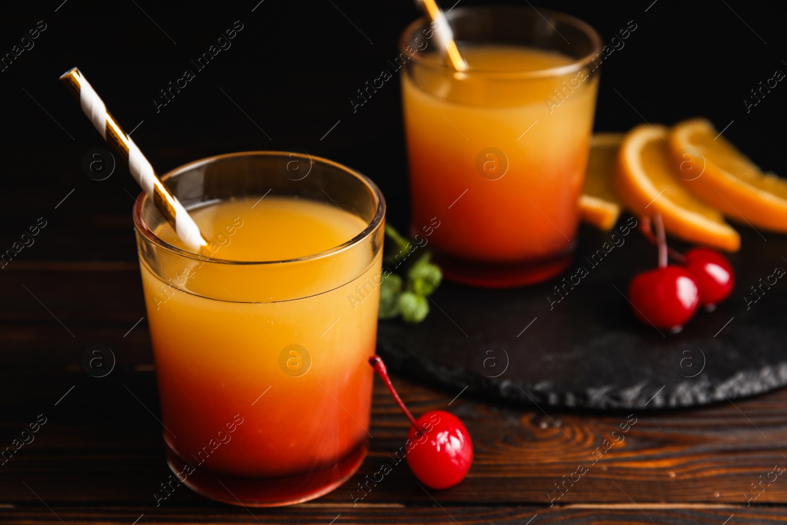Photo of Fresh alcoholic Tequila Sunrise cocktail on wooden table