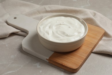 Photo of Bowl of fresh yogurt on grey table