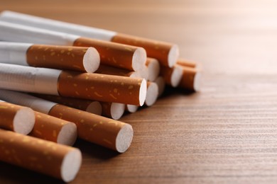 Pile of cigarettes on wooden table, closeup