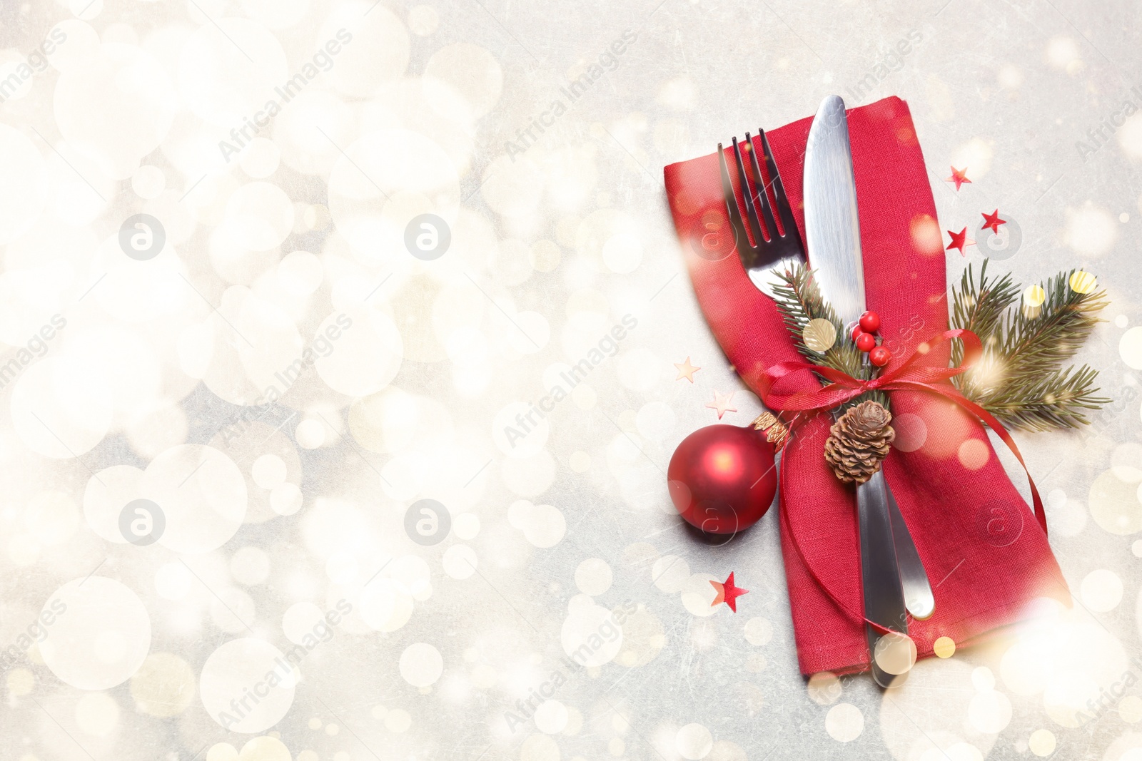 Image of Cutlery set and Christmas decor on light grey table, flat lay. Space for text