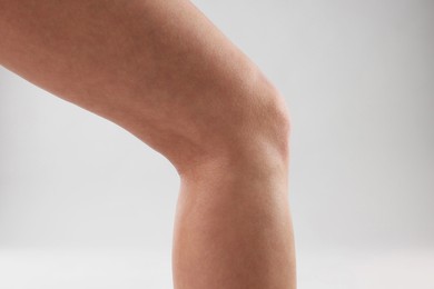 Woman with slim legs on grey background, closeup