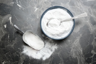 Kitchenware with baking soda on grey background, top view