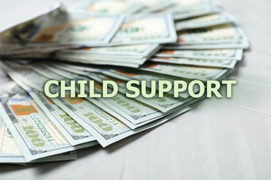 Image of Child support concept. Many dollar banknotes on white wooden background, closeup