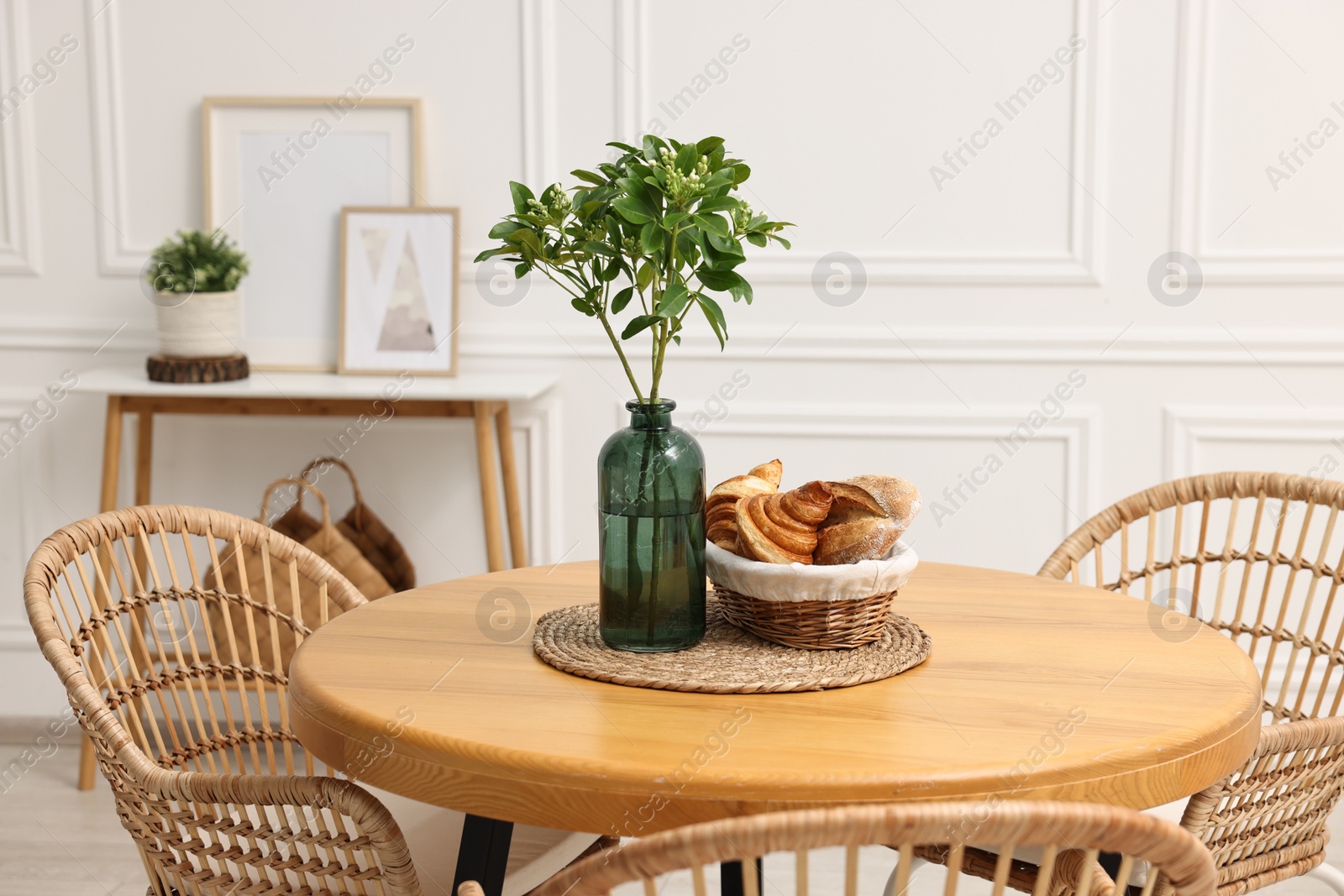 Photo of Dining room interior with comfortable furniture and green branches