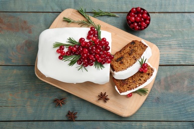 Traditional Christmas cake and ingredients on light blue wooden table, flat lay. Classic recipe