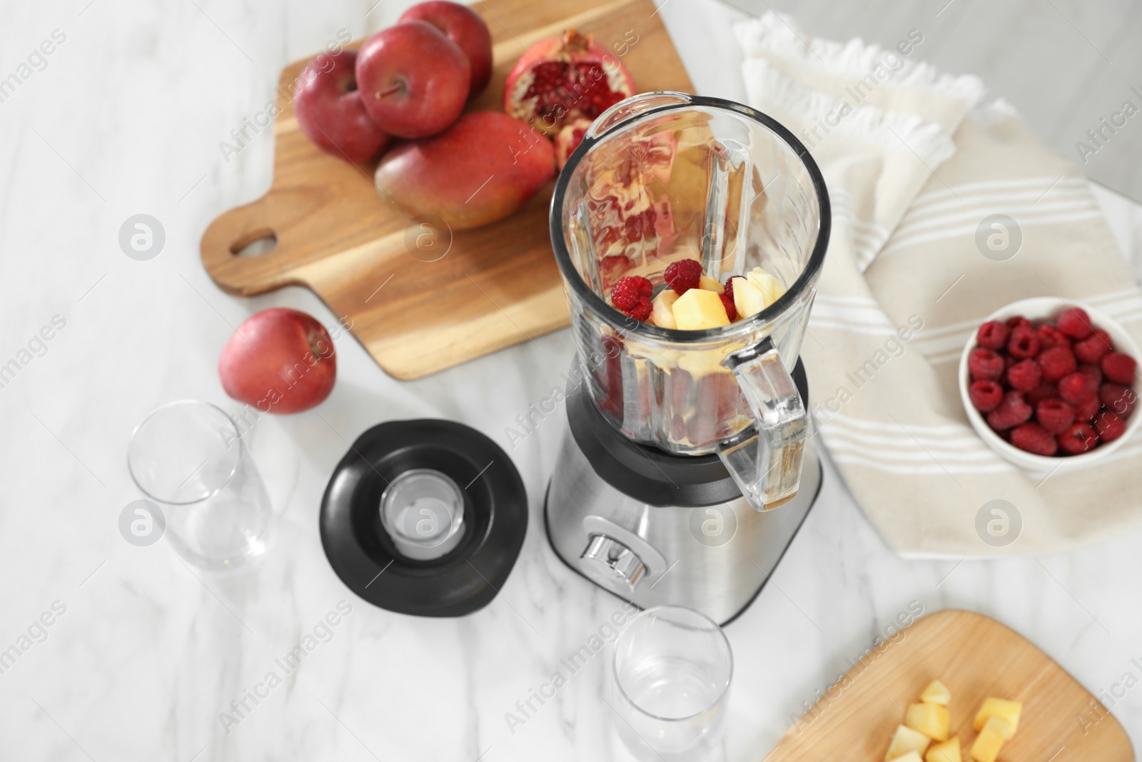 Photo of Blender with smoothie ingredients on white marble table in kitchen, above view