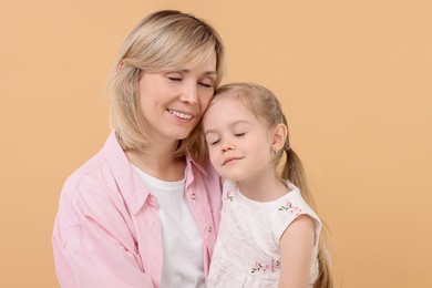Photo of Family portrait of happy mother and daughter on beige background