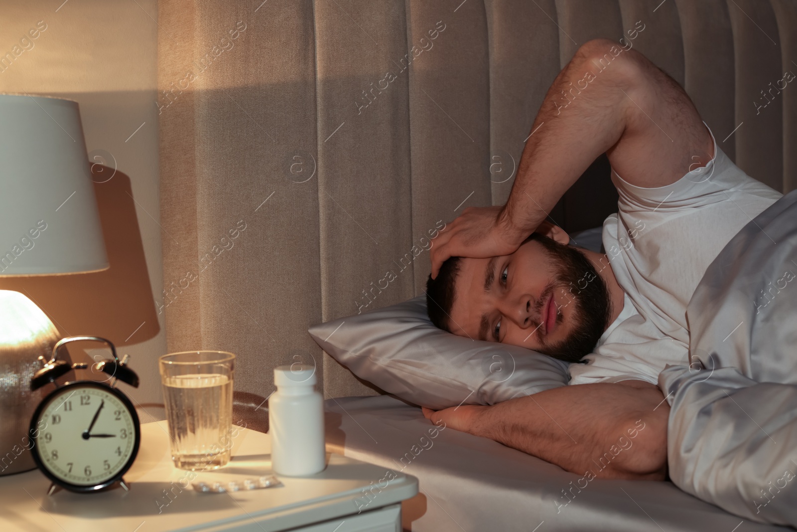 Photo of Man suffering from insomnia in bed at night