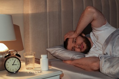 Photo of Man suffering from insomnia in bed at night