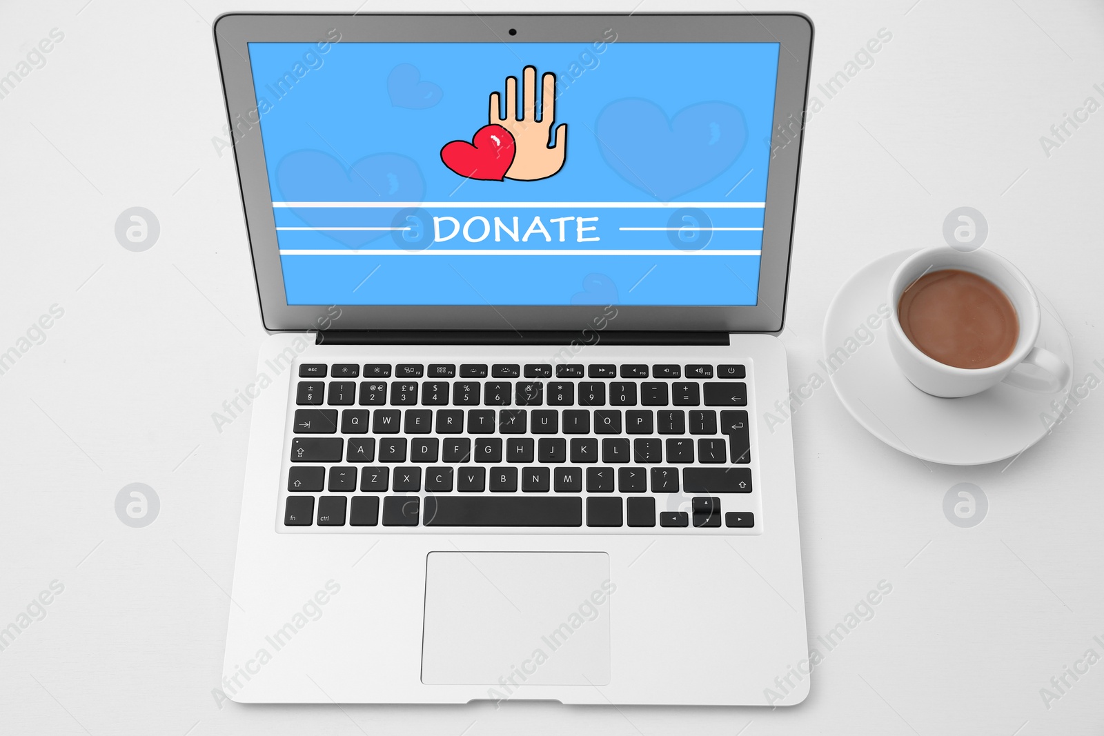 Image of Donations concept. Modern laptop and cup of coffee on white table