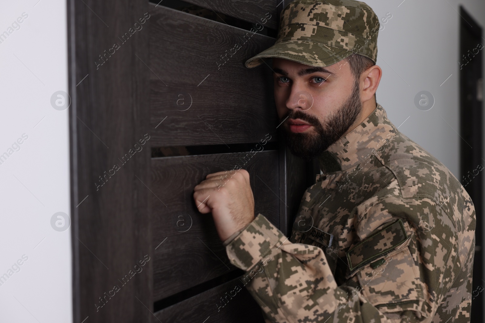 Photo of Military commissariat representative knocking on wooden door