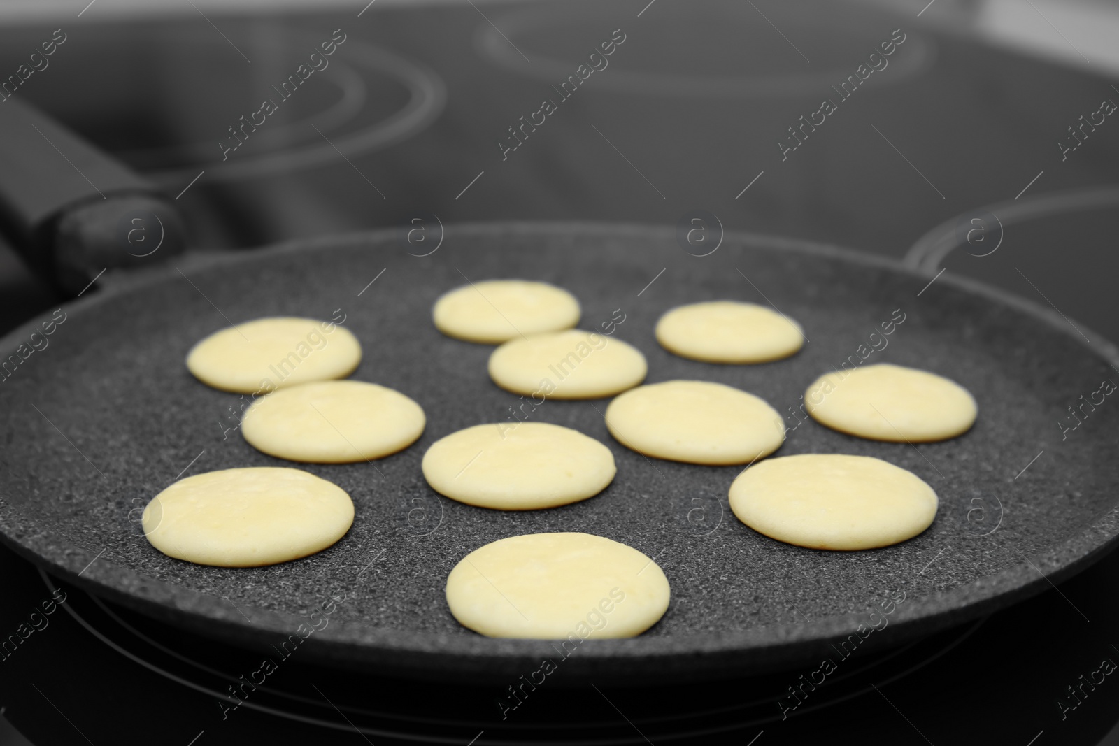 Photo of Frying tasty cereal pancakes on modern stove