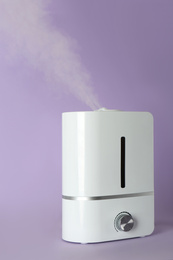 Photo of New modern air humidifier on violet background