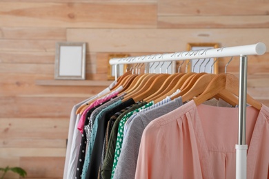 Photo of Wardrobe rack with stylish female clothes indoors, space for text