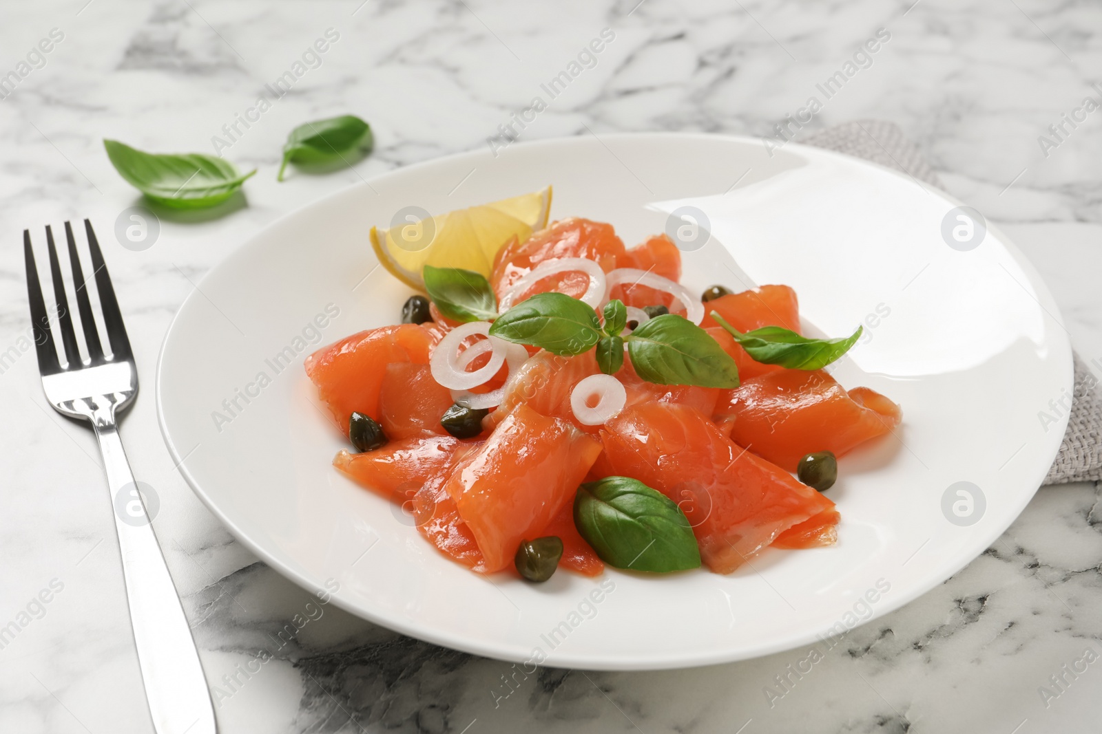 Photo of Delicious salmon carpaccio served on white marble table, closeup