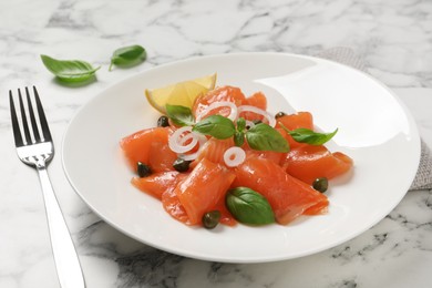 Photo of Delicious salmon carpaccio served on white marble table, closeup