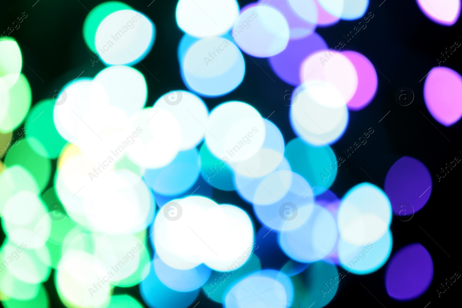 Photo of Blurred view of colorful lights on black background. Bokeh effect