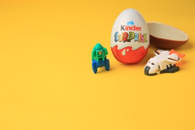 Sveti Vlas, Bulgaria - June 29, 2023: Kinder Surprise Eggs and toys on orange background, space for text