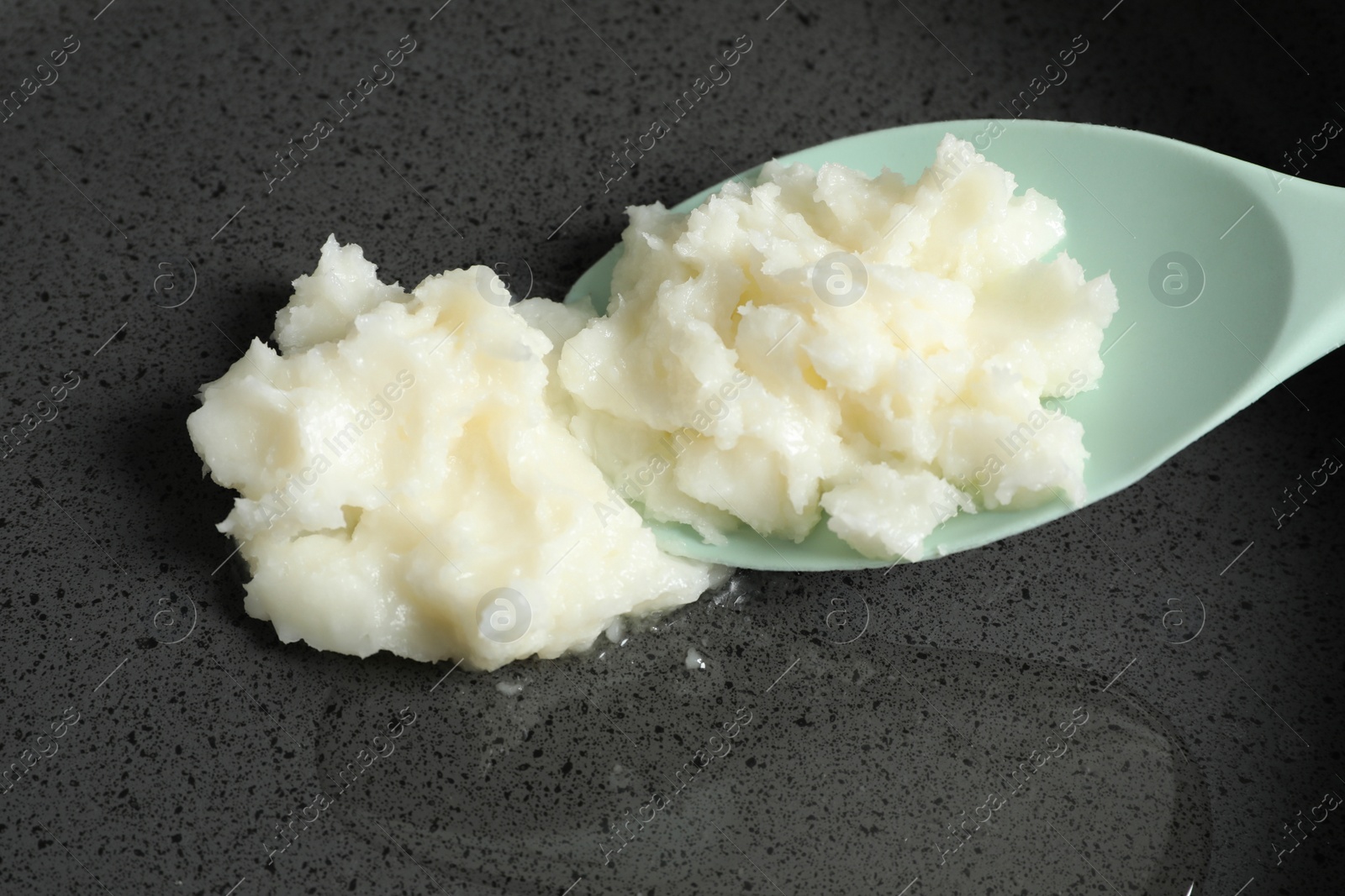 Photo of Frying pan with coconut oil and spoon, closeup. Healthy cooking