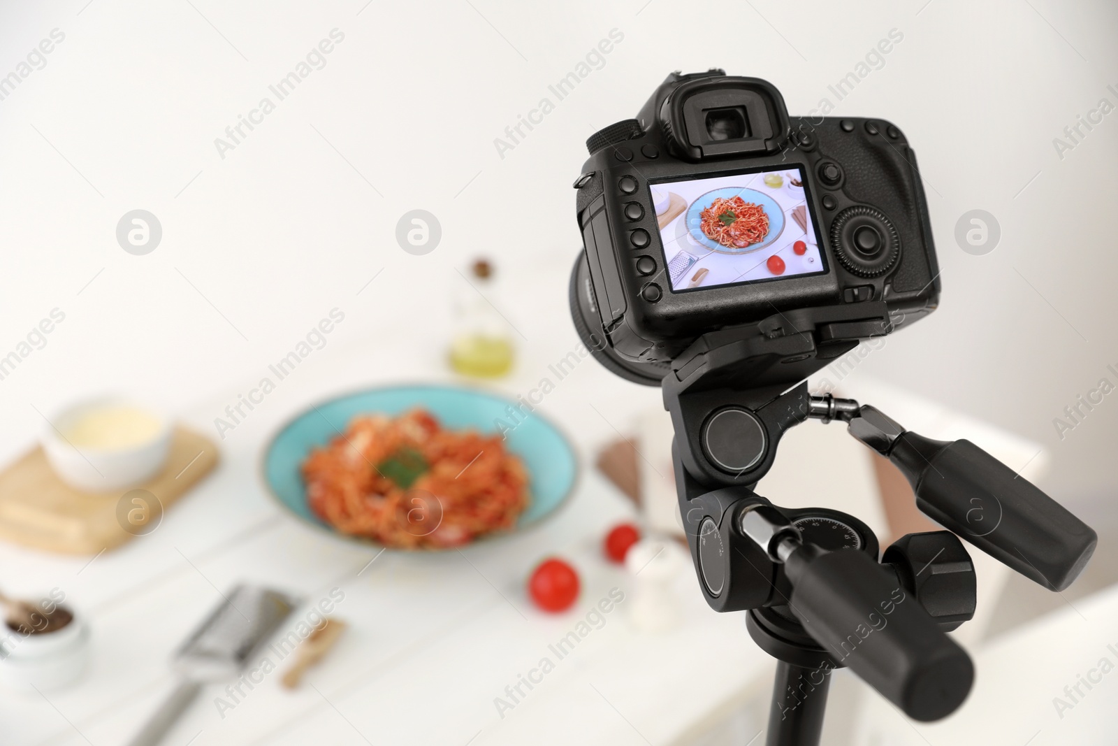 Photo of Professional camera with picture of spaghetti on display in studio, space for text. Food stylist