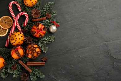 Flat lay composition with pomander balls made of fresh tangerines on dark table. Space for text