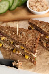Photo of Delicious sandwiches with tuna and vegetables on white table, closeup