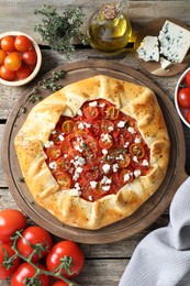 Photo of Flat lay composition of tasty galette with tomato, thyme and cheese (Caprese galette) on wooden table