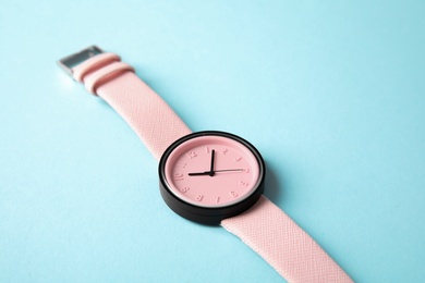 Photo of Stylish wrist watch on color background. Fashion accessory