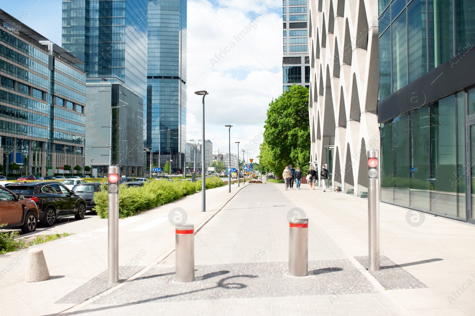 Photo of Beautiful bollards near buildings with many windows on cloudy day in city