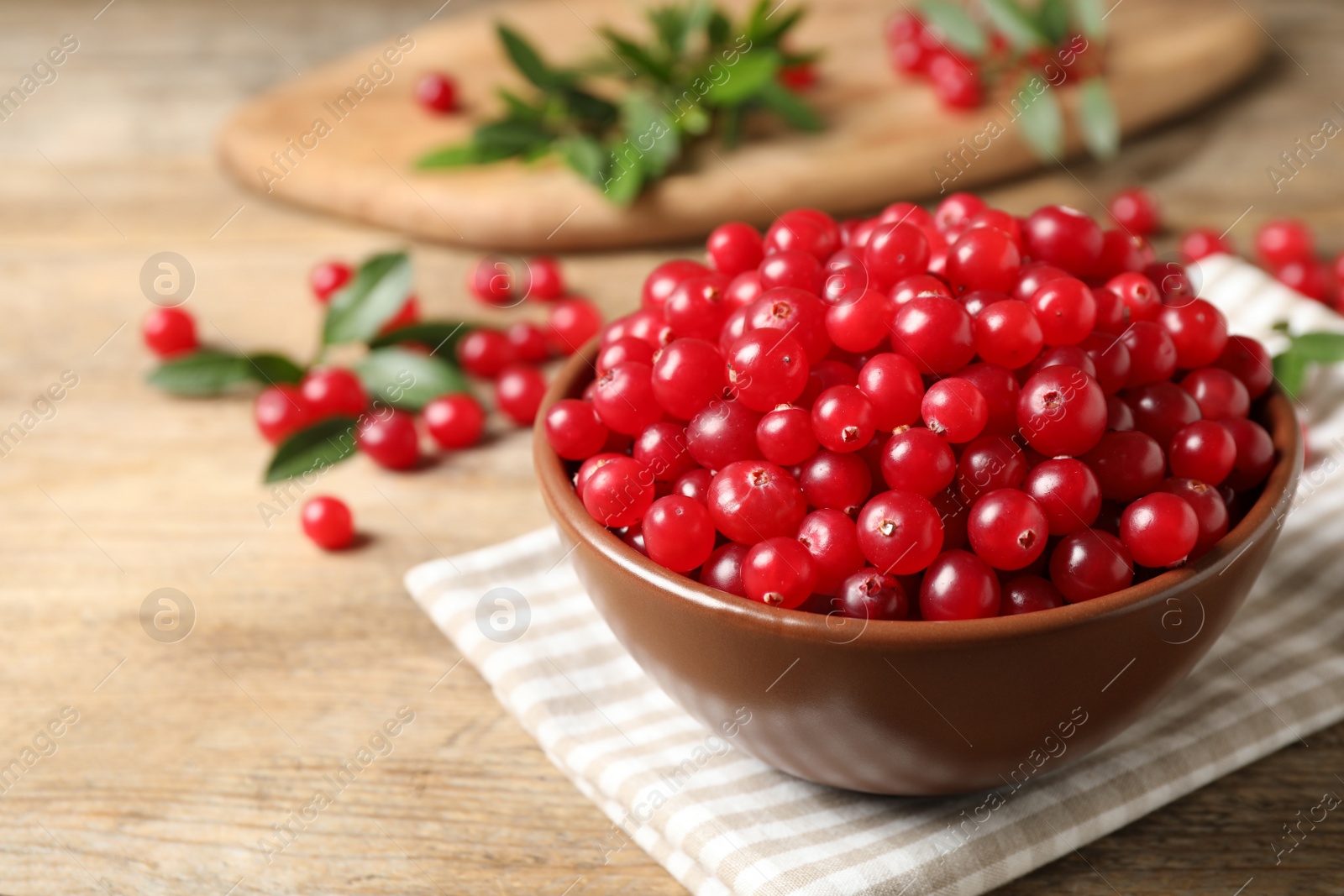 Photo of Tasty ripe cranberries on wooden table, closeup